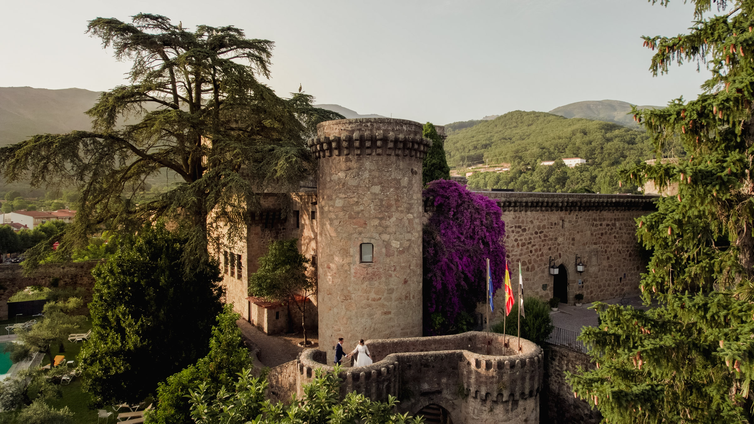 Desde el cielo, la vista aérea captura la imagen encantadora de Belén y Luisma bailando en las torres del Parador de Jarandilla. Fotógrafos de bodas en Extremadura. Boda en el Parador de Jarandilla de la Vera